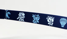 Cargar imagen en el visor de la galería, Detalle de varilla de gafas de sol de las Hogueras de Alicante, con estampado artesanal de símbolos festivos valencianos en azul marino y celeste