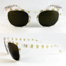 Cargar imagen en el visor de la galería, Gafas de sol falleras blancas con cristales oscuros y dibujos dorados inspirados en motivos tradicionales valencianos.