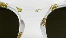 Cargar imagen en el visor de la galería, Detalle frontal de gafas de sol falleras blancas con cristales oscuros y motivos dorados tradicionales valencianos de Peinetta Roja.
