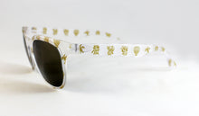 Cargar imagen en el visor de la galería, Gafas falleras transparentes con cristales negros y dibujos dorados de pardalets, peinetas y motivos florales para fiestas valencianas y alicantinas
