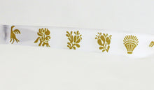 Cargar imagen en el visor de la galería, Detalle de patilla blanca de gafas de sol falleras con dibujos dorados inspirados en motivos tradicionales valencianos de Peinetta Roja.
