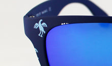 Cargar imagen en el visor de la galería, Gafas de sol de las Hogueras de Alicante en azul marino mate con motivo del ave fallera repetido, detalle de acabado y cristal espejo azul, regalo original para fallas y hogueras
